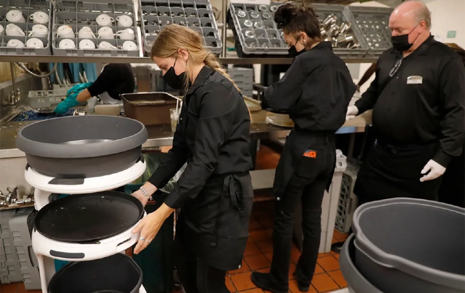 Server Alli Wynn unloads dirty dishes from a robot named “Robbie” at Stoneridge Creek Pleasanton 