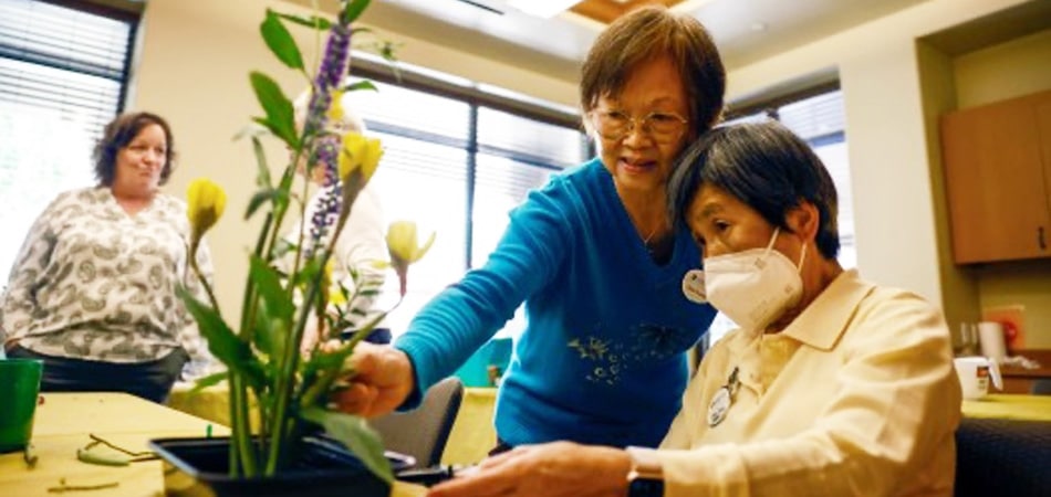 Stoneridge Creek residents arranging flowers in an Ikebana Club at the community.