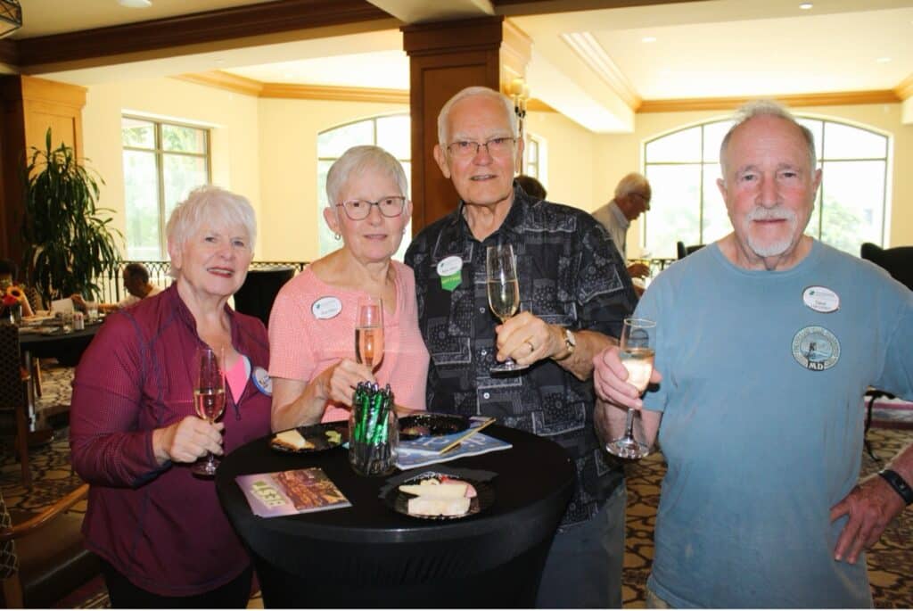 Four seniors pose for a toast with champagne